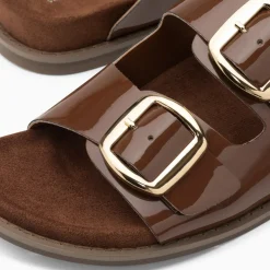 Mules plates Célia marron verni à boucles oversize