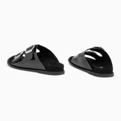 Mules plates Célia noir verni à boucles oversize